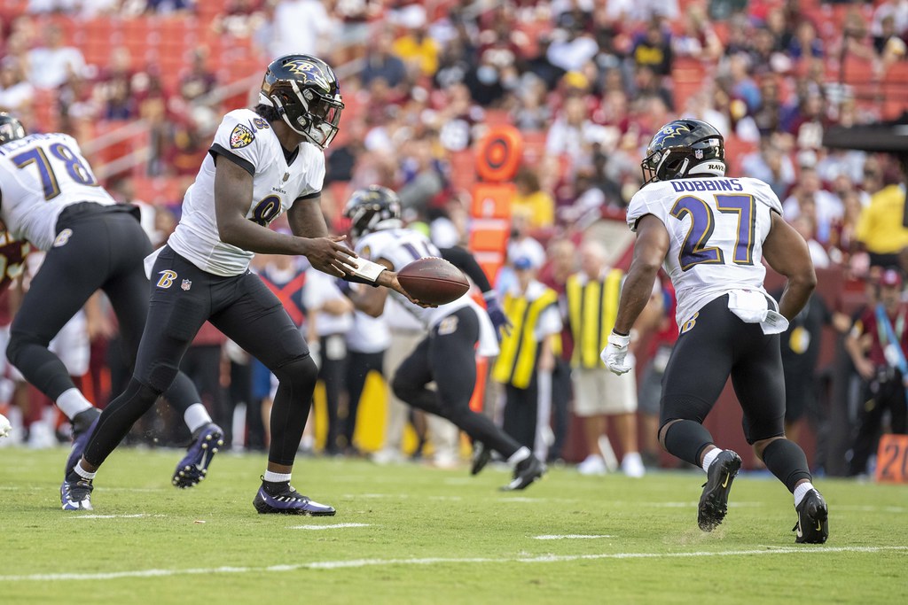 Quarterback Lamar Jackson handing the ball off to JK Dobbins.